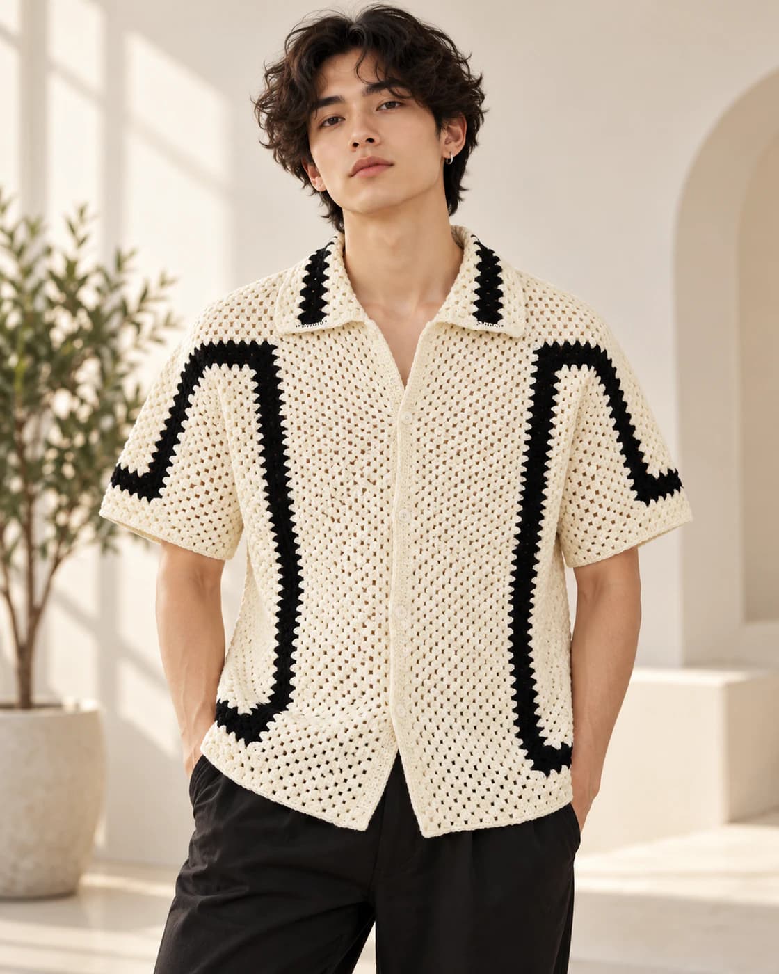 Model wearing the cream and black crochet shirt with black trousers